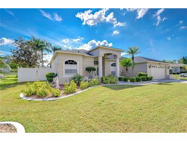 Single-story home with landscaped yard, driveway, and attached garage at 8704 Cypress Lakes Blvd, New Port Richey, FL 34653