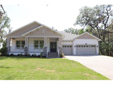 Charming single-story home with a welcoming front porch, manicured lawn, and a convenient two-car garage at 6392 Summit View Dr, Brooksville, FL 34601