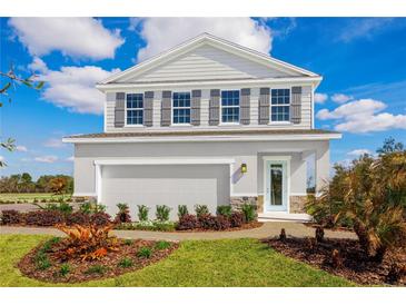 Two-story home with gray siding, gray shutters, and a light blue front door at 10421 High Noon Trl, Parrish, FL 34219