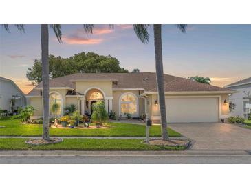 Beautiful home with a landscaped yard, a two-car garage, and a welcoming front porch at 8231 Coral Creek Loop, Hudson, FL 34667