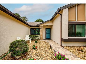 Inviting front entrance with landscaped walkway and seating area at 7499 Heather Walk, Weeki Wachee, FL 34613