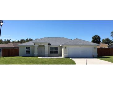 Newly constructed home with a gray roof, white exterior, and a two-car garage at 10115 Briar Cir, Hudson, FL 34667