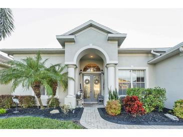 A charming one-story house features a welcoming front porch and well-manicured landscaping at 2533 Wood Pointe Dr, Holiday, FL 34691