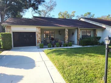 Cozy single-story home with a stone facade and landscaped front yard at 6580 Brambleleaf Dr, Spring Hill, FL 34606