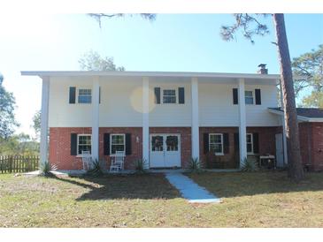 Brick ranch house with white columns and double front doors at 8700 Ross Ln, New Port Richey, FL 34654