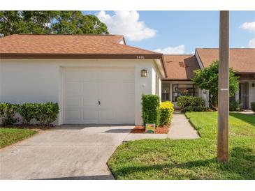 Front view of a charming villa with a well-maintained lawn and attached garage at 3416 Lori Ln # 4, New Port Richey, FL 34655