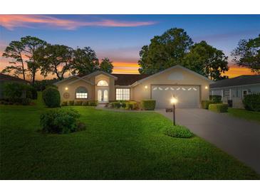 Beautiful home with a two-car garage and well-manicured lawn at dusk at 2300 Whisper Walk Dr, Spring Hill, FL 34606