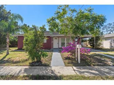 Red house with a white door and well-maintained lawn at 6512 Spring Hill Dr, Spring Hill, FL 34606