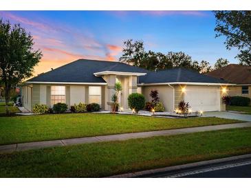 Attractive single-story home with a well-manicured lawn and landscape lighting at 10464 Henderson St, Spring Hill, FL 34608