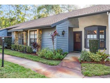 Charming condo with gray siding, stone accents, and well-manicured landscaping at 2106 Forester Way, Spring Hill, FL 34606