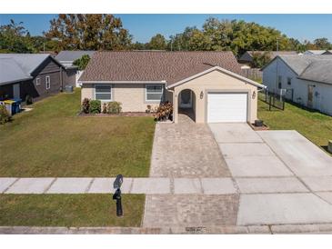 Single-story home with a brick paver driveway and well-manicured lawn at 7745 Jenner Ave, New Port Richey, FL 34655