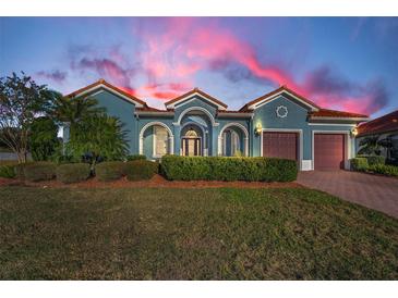 Beautiful teal home with a red tile roof, two-car garage, and lush landscaping at 10645 Ruffino Ct, Trinity, FL 34655