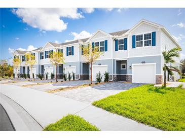 Row of townhouses with attached garages and landscaping at 12458 Amber Creek Cir, Lakewood Ranch, FL 34211