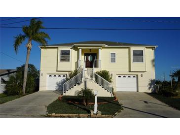 Two-story house with attached two-car garage, and a manicured lawn at 13730 Gene Rossi Ave, Hudson, FL 34667