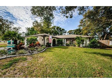 Landscaped front yard with stone border and colorful plants at 7509 Cypress Knee Dr, Hudson, FL 34667