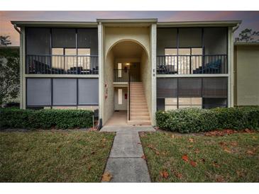 Two-story condo building with screened balconies and landscaping at 1354 Shady Pine Way # H2, Tarpon Springs, FL 34688