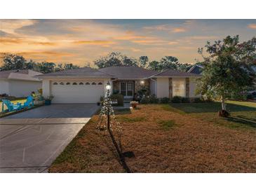 Inviting home with a well-manicured lawn, attached garage, and charming curb appeal at 6156 Spyglass Ct, Spring Hill, FL 34606