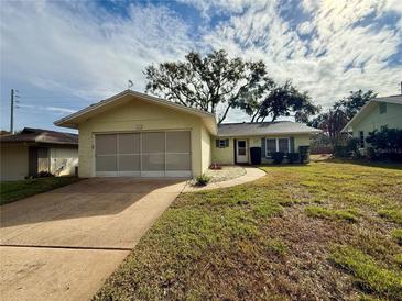 Ranch-style home with a single-car garage and well-maintained lawn at 8704 Winding Wood Dr, Port Richey, FL 34668