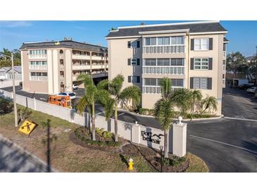 Exterior view of Port Bellaire condo community featuring lush landscaping and building entry at 155 Bluff View Dr # 103, Belleair Bluffs, FL 33770
