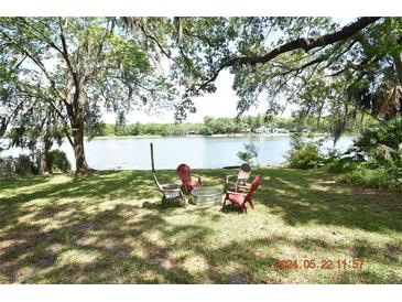 Relaxing backyard with fire pit and lake view at 3606 River Grove Dr, Tampa, FL 33610