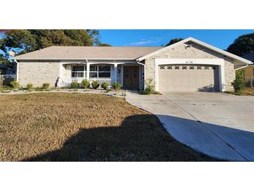 Brick ranch house with attached garage and well-maintained lawn at 6288 Airmont Dr, Spring Hill, FL 34606