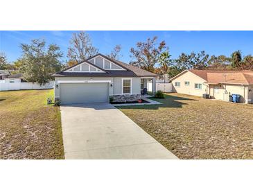 One-story house with gray siding, stone accents, and a two-car garage at 2509 Magellan Ave, Spring Hill, FL 34608