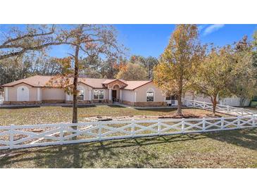 Single-story house with white fence and a large yard at 5085 Bone Ln, Brooksville, FL 34604