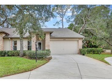 Brick front exterior of charming villa with attached garage and landscaped lawn at 6218 Hardscrabble Ct, Spring Hill, FL 34606