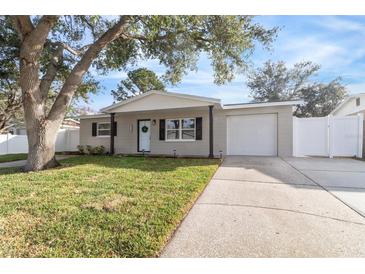 Newly renovated home with a landscaped yard and driveway at 9240 Whitman Ln, Port Richey, FL 34668