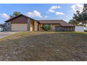 House exterior featuring a ranch-style home with a stone facade and attached garage at 9470 Montebello Ln, Spring Hill, FL 34608