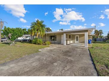 Charming single-story home with covered carport and tropical landscaping at 106 Aurora E St, Venice, FL 34285