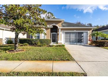 Single-story house with a screened porch and landscaped lawn at 11202 Paradise Point Way, New Port Richey, FL 34654