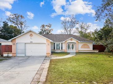 Single-story house with a two-car garage and well-manicured lawn at 8474 Day St, Spring Hill, FL 34606