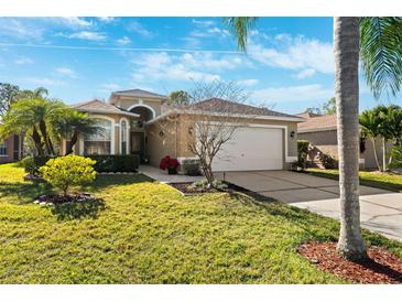 Charming single-story home featuring lush landscaping and a well-manicured lawn with a two car garage at 4886 Westchester Ct, Oldsmar, FL 34677