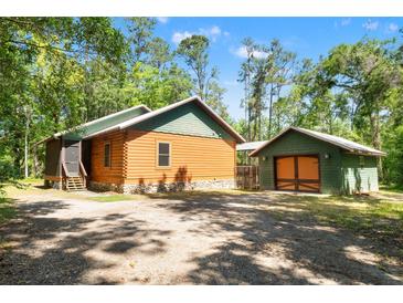 Charming log cabin home with lush surroundings and separate garage at 6051 Valley Spring Dr, Brooksville, FL 34601