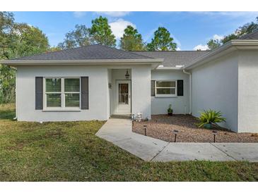 Charming single-story home features a walkway, well-maintained landscaping, and neutral exterior at 11085 Stilt Ave, Brooksville, FL 34614