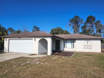 Charming one-story home featuring a neutral color scheme, attached two-car garage, and manicured lawn at 6141 Freeport Dr, Spring Hill, FL 34606