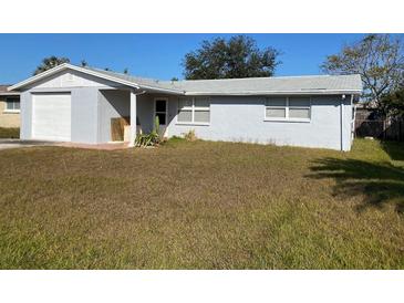 Charming single-story home with an attached garage and a well-maintained front yard on a sunny day at 3421 Allandale Dr, Holiday, FL 34691