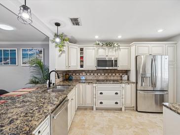 Bright kitchen features granite countertops, stainless steel appliances, and ample cabinet storage at 3259 Hilary Cir # 1C, Palm Harbor, FL 34684