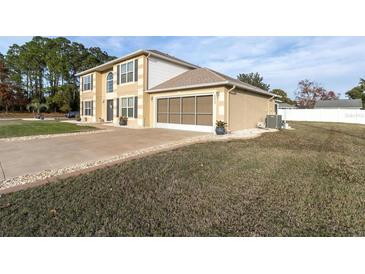 Two-story home featuring an attached two-car garage, well-maintained lawn, and mature landscaping at 4332 Lamson Ave, Spring Hill, FL 34608