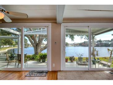 Living room with sliding glass doors leading to a patio overlooking the water at 12501 Ulmerton Rd # 19, Largo, FL 33774