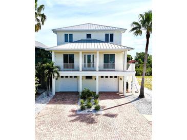 Stunning two-story home with a brick driveway, multiple car garage, and a charming balcony at 1421 Apollo Beach Blvd, Apollo Beach, FL 33572