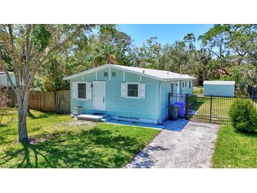 Charming single-story home featuring a well-manicured lawn, white-trimmed windows, and a cozy front entrance at 1888 Douglas Ave, Dunedin, FL 34698