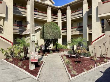 Multi-story condo building featuring well-maintained landscaping and assigned parking spaces at 4529 Whitton Way # 214, New Port Richey, FL 34653