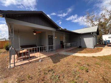 Charming home featuring a covered front porch with a cozy swing and ceiling fan at 13026 Lawrence St, Spring Hill, FL 34609