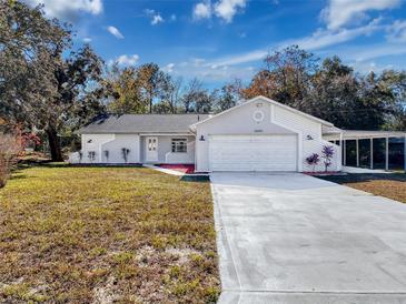 Charming single-story home features an attached two-car garage and long driveway at 12242 Greenwood St, Brooksville, FL 34613