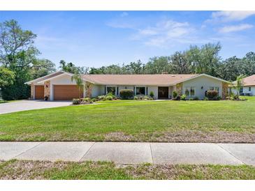 Charming single-story home with manicured lawn, stone accents, and a welcoming front entrance at 4603 Lake In The Woods Dr, Spring Hill, FL 34607