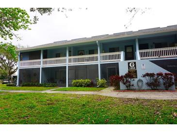 A charming two-story light-blue condo with white railings and well-maintained landscaping at 1955 Abrico Dr # G12, Lutz, FL 33558