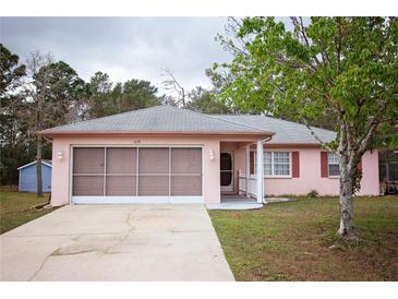 Charming single-story home with a screen garage, beautiful landscaping, and a spacious driveway at 2171 Whitewood Ave, Spring Hill, FL 34609