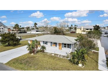 Charming one-story home featuring a well-maintained front yard and a spacious concrete driveway at 3449 Companero Entra, Hernando Beach, FL 34607